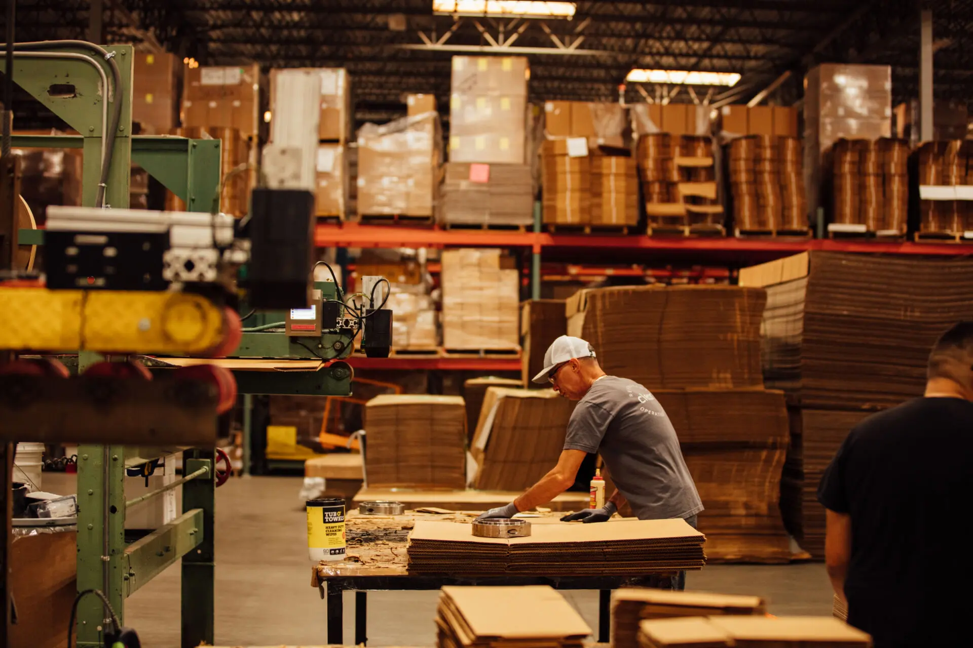 Worker assembles cardboard packaging in an industrial packaging warehouse